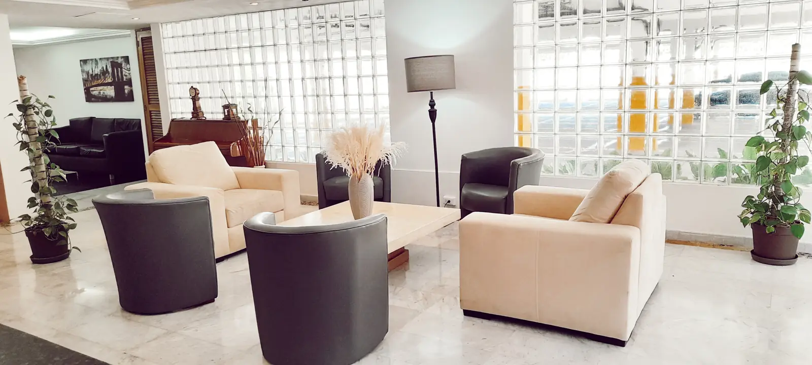 Lobby con muebles claros y paredes de bloques de vidrio